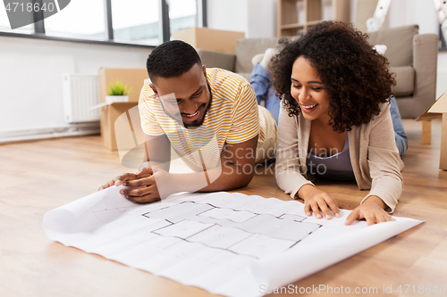 Image of couple with boxes and blueprint moving to new home