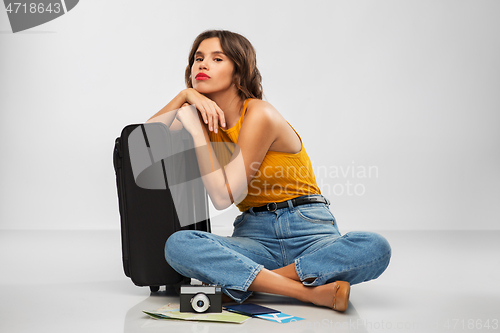 Image of woman with travel bag, air ticket, map and camera