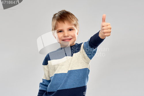 Image of little boy in striped pullover showing thumbs up