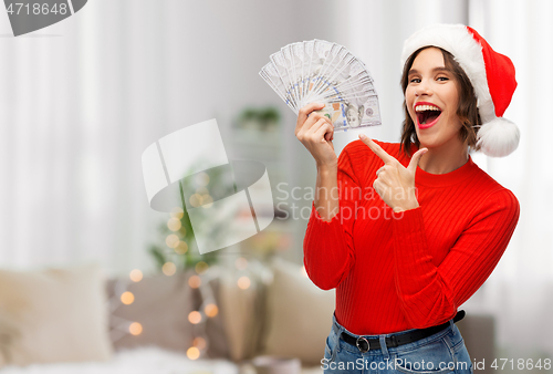 Image of happy woman in santa hat with money on christmas