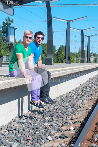 Image of Shot of two young men sitting on platform