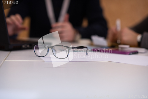 Image of laptop and glasses at office desk