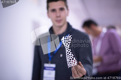 Image of young engineer showing 3D printed model