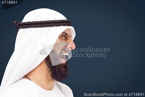 Image of Arabian saudi businessman on dark blue studio background