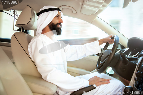 Image of Arabian saudi businessman driving hir car