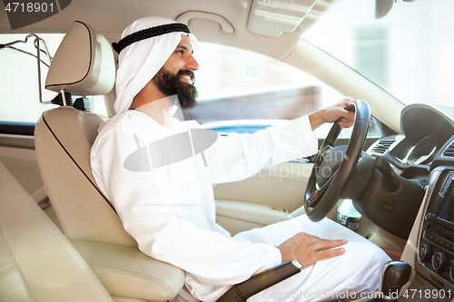 Image of Arabian saudi businessman driving hir car