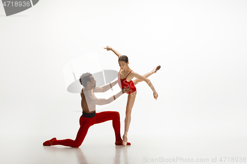 Image of Young graceful couple of ballet dancers dancing on white studio background