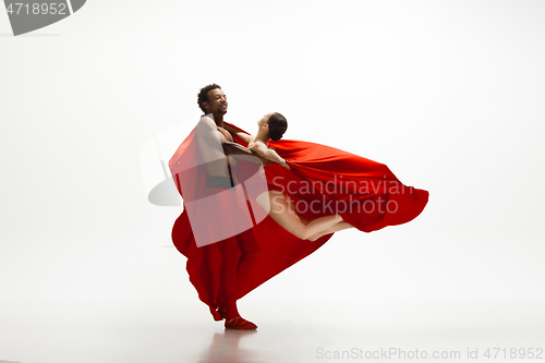 Image of Young graceful couple of ballet dancers dancing on white studio background