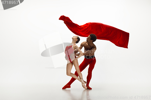 Image of Young graceful couple of ballet dancers dancing on white studio background