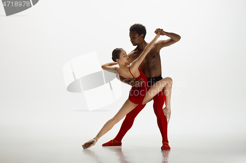 Image of Young graceful couple of ballet dancers dancing on white studio background