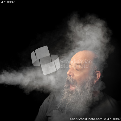 Image of bearded man gets smoke in his face portrait