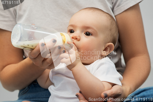 Image of close up of mother feeding baby with milk formula