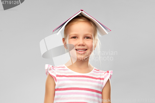 Image of little girl with roof of book on top of her head