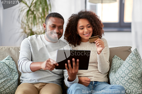 Image of couple with tablet pc and credit card at home