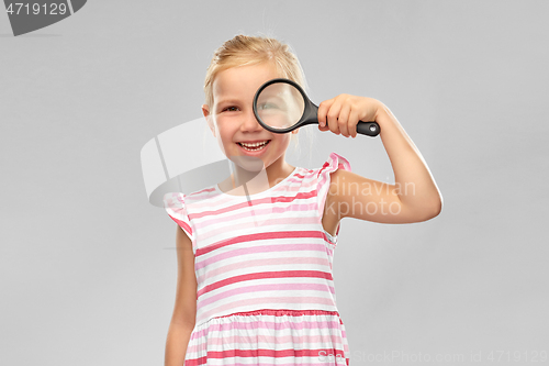 Image of happy girl looking through magnifying glass