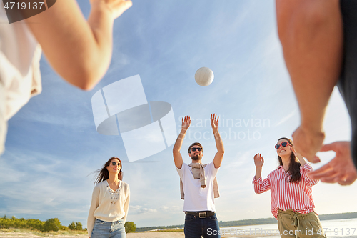 Image of friends playing volleyball on beach in summer