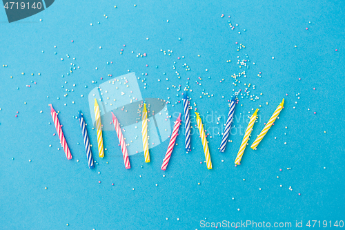 Image of birthday candles with sprinkles on blue background