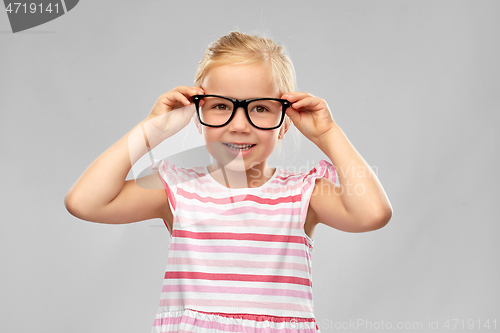 Image of smiling cute little girl in black glasses