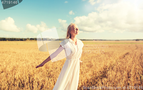 Image of smiling young woman in white dress on cereal field