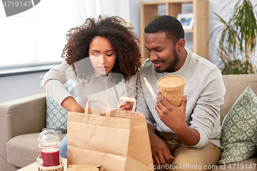 Image of happy couple with takeaway food and drinks at home