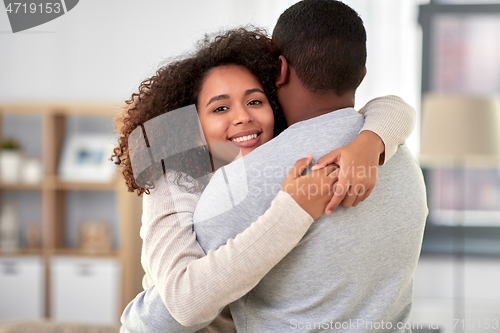 Image of happy african american couple hugging at home