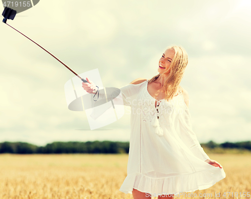 Image of happy young woman taking selfie by smartphone