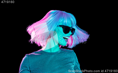 Image of happy woman in pink wig and sunglasses dancing