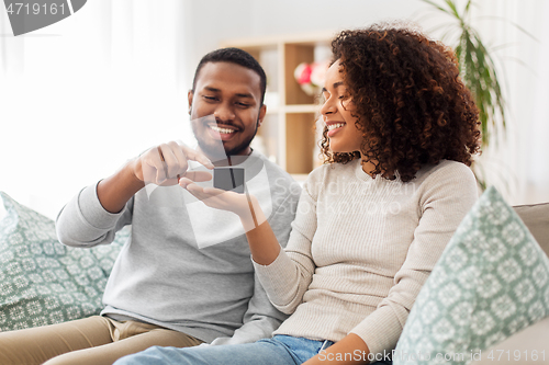 Image of african american couple with smart speaker at home