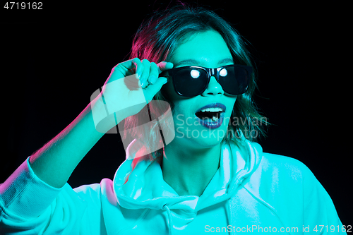 Image of woman wearing hoodie in neon lights over black