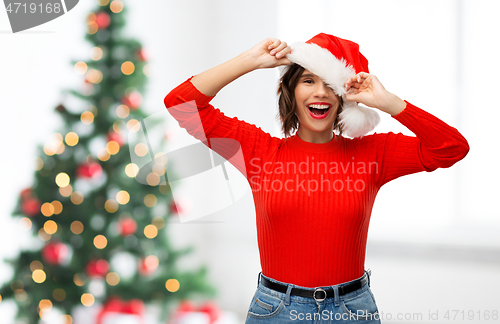 Image of happy young woman in santa hat on christmas