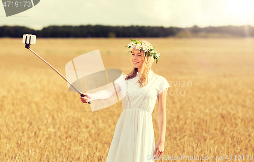 Image of happy young woman taking selfie by smartphone