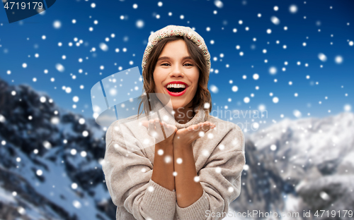 Image of young woman in knitted winter hat in mountains