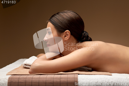 Image of young woman lying at spa or massage parlor