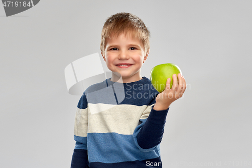 Image of little boy in striped pullover with green apple