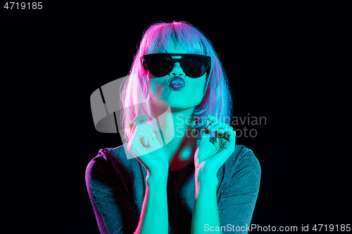 Image of woman in wig and black sunglasses sending air kiss