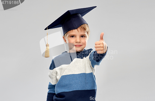 Image of little boy in mortarboard showing thumbs up