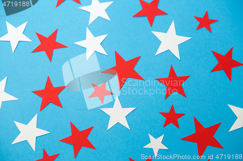 Image of star shaped confetti decoration on blue background