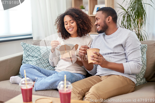 Image of happy couple with takeaway food and drinks at home