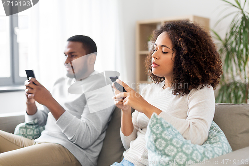 Image of african american couple with smartphone at home