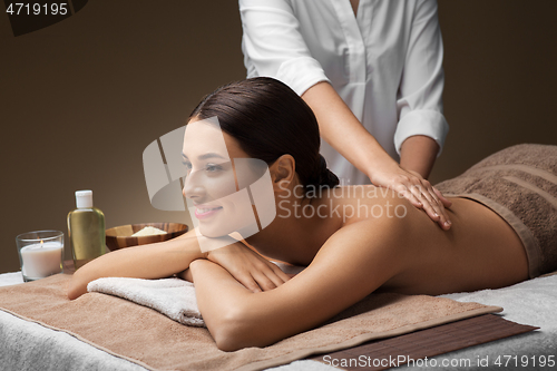 Image of woman lying and having back massage at spa