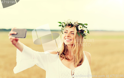 Image of happy young woman taking selfie by smartphone