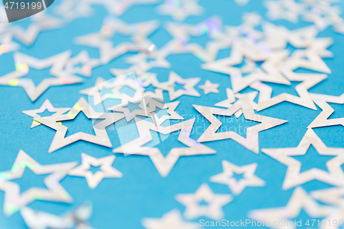 Image of star shaped confetti decoration on blue background