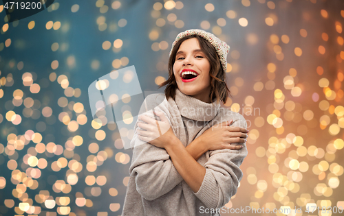 Image of young woman in knitted winter hat and sweater