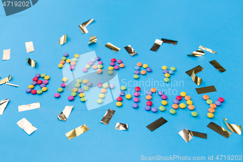 Image of happy birthday of candies and confetti on blue