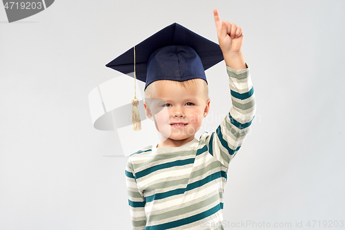 Image of little boy in mortar board pointing finger up