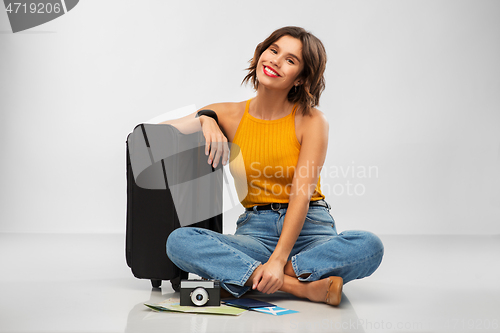 Image of woman with travel bag, air ticket, map and camera