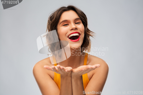 Image of happy young woman holding something on empty hands