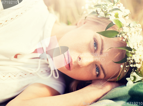 Image of happy woman in wreath of flowers on cereal field