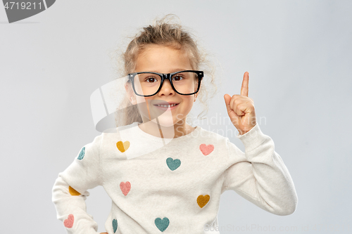 Image of portrait of girl in glasses pointing finger up