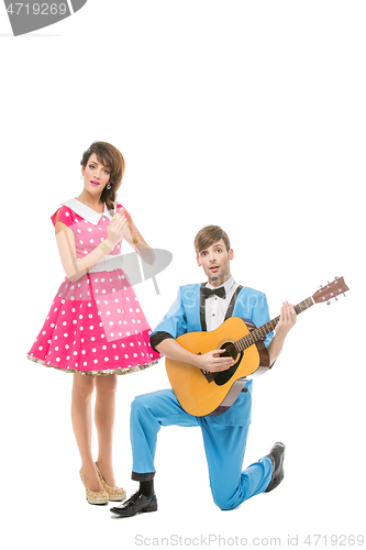 Image of doll looking boy and girl with guitar